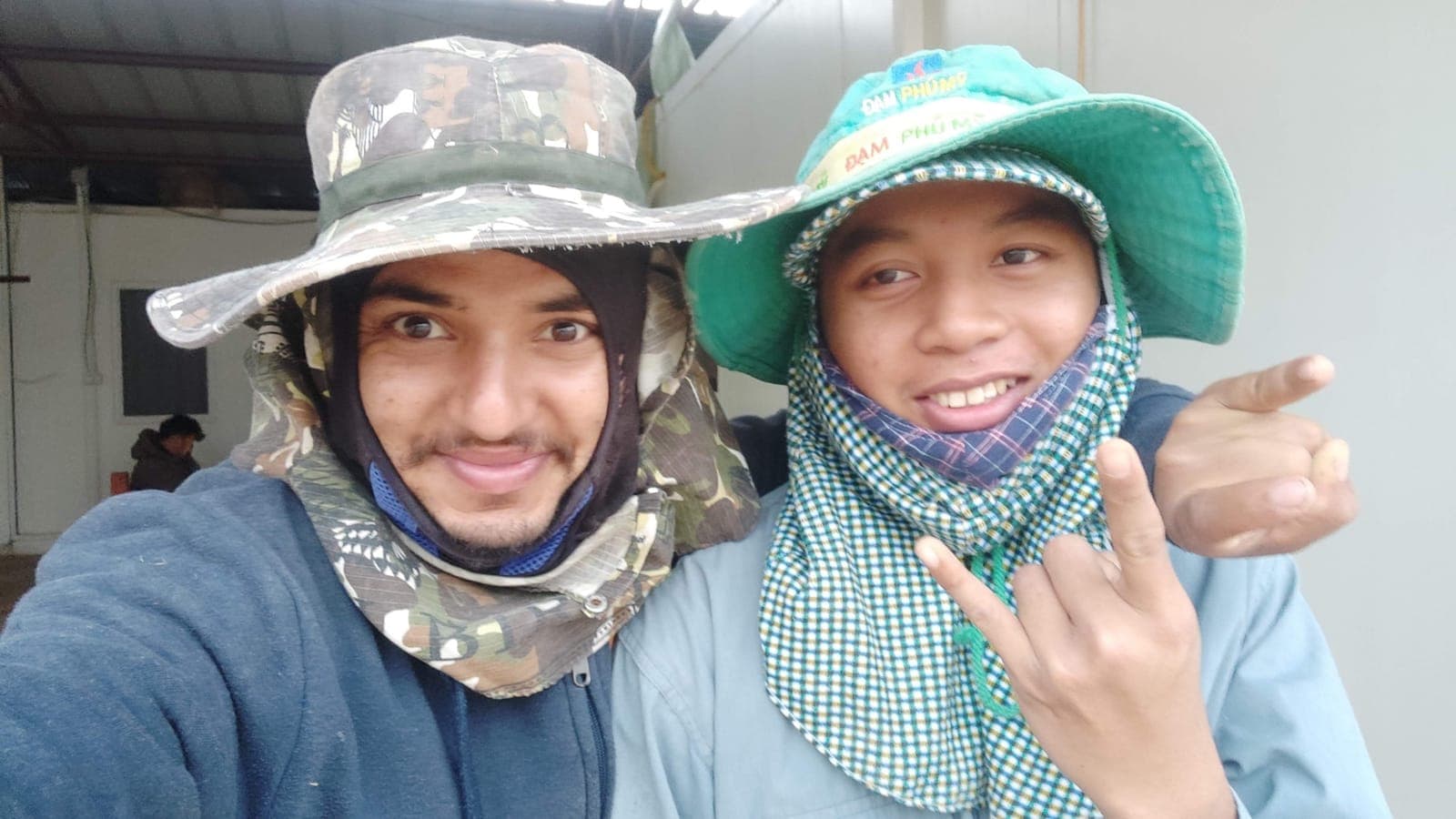Rabin Paudel and a fellow trainee in sun hats and face covers